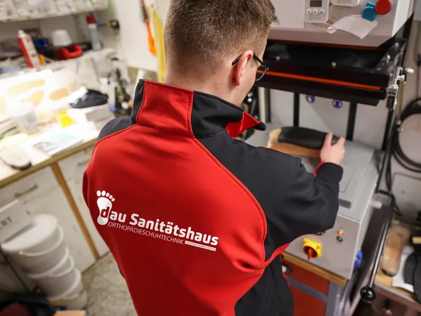 Paul Leyske von hinten an einer Presse in der Werkstatt in Dannenberg